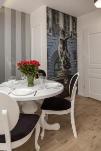 a dining room with a white table and chairs at Apartamenty Gdańsk EU - Angielska Grobla OLD TOWN Gdańsk sw Barbary 11 in Gdańsk