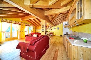 a living room with wooden ceilings and red chairs at Luxury Exclusive Attic in Pinzolo +41 photos