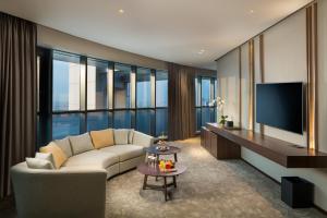 a living room with a couch and a tv at Millennium Place Barsha Heights Hotel in Dubai
