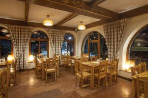 a restaurant with wooden tables and chairs and windows at Schronisko PTTK Orlica in Szczawnica