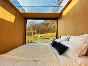 a bed in a room with a large glass window at Bleu Minuit L'Arche in Obersteinbach
