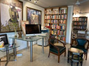 a library with a desk with a computer and chairs at Art house Vasant Vihar New Delhi in New Delhi