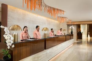 a group of men in pink shirts in a lobby at Millennium Place Barsha Heights Hotel in Dubai +27 photos