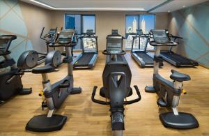 a gym with several treadmills and elliptical machines at Millennium Place Barsha Heights Hotel in Dubai