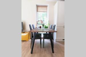 comedor con mesa de madera y sillas en Karusselli Apartment en Pärnu