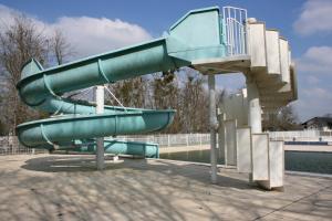 a green water slide in a park with a slide at The Petite Chalet Chambre d'hôtes in LʼIsle-Jourdain