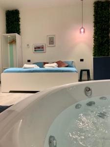 een bad in een kamer met een bed bij AJ Lux Apartments in Catania
