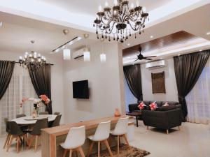 a living room with a chandelier and a dining room at Sea Lion Kuala Selangor Semi-Detached Homestay in Kuala Selangor