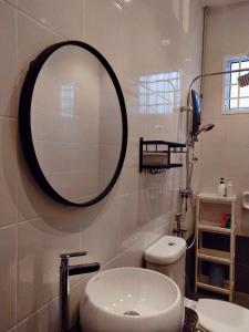 a bathroom with a mirror and a toilet at Sea Lion Kuala Selangor Semi-Detached Homestay in Kuala Selangor