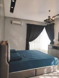 a bedroom with a blue bed and a window at Sea Lion Kuala Selangor Semi-Detached Homestay in Kuala Selangor