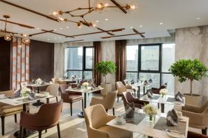 a restaurant with tables and chairs and windows at Millennium Place Barsha Heights Hotel in Dubai