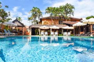 a large swimming pool with chairs and umbrellas at Pousada dos Condes Maresias in Maresias