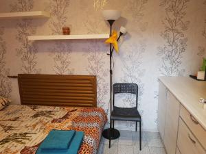 クラスノダールにあるGuest House Kalyaevaのベッドルーム(ベッド1台、ランプ、椅子付)