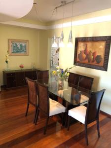 a dining room with a glass table and chairs at Apartamento amplo, arejado e confortável - Mínimo 3 noites in Ilhéus