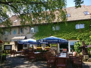 ein Restaurant mit Tischen und Stühlen und ein Gebäude in der Unterkunft Lechstedter Obstweinschänke in Bad Salzdetfurth