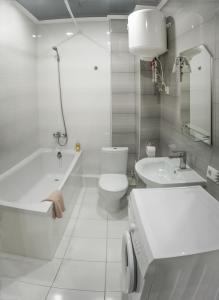 a white bathroom with a tub and a toilet and a sink at Видовая квартира в новострое в центре Киева in Kyiv