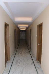 an empty corridor in a building with doors and ceilings at HOTEL SHIVAM in Hāora