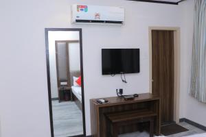 a room with a mirror and a television on a wall at HOTEL SHIVAM in Hāora