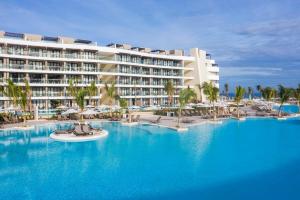 un complexe avec une grande piscine bordée de palmiers dans l'établissement Ocean Coral Spring Resort - All Inclusive, à Spring Rises