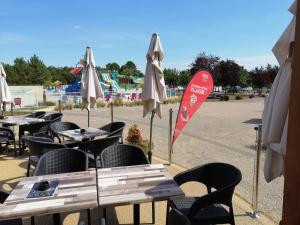 a group of tables and chairs with umbrellas at jpp marie ange proprietaire in Saint-Julien-en-Born