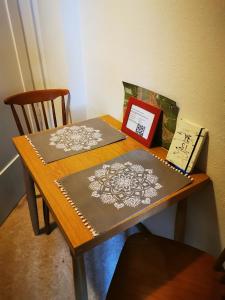 uma mesa de madeira com dois tapetes e um livro sobre ela em Heidi's Home em Garmisch-Partenkirchen