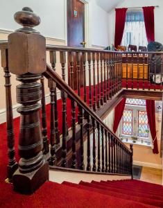 una scala in una casa con tappeto rosso di The Tudor Lodge a Skegness