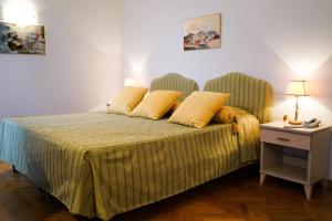 a bedroom with a bed with yellow pillows on it at Hotel Cappelli in Montecatini Terme