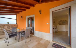 a dining room with orange walls and a table and chairs at Holiday home Angelina in Pazin