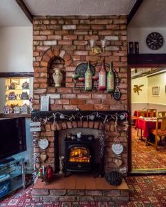 uma sala de estar com lareira de tijolos e garrafas de vinho em The Tudor Lodge em Skegness