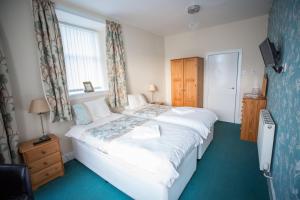 een slaapkamer met een groot wit bed met een raam bij Smithfield Guesthouse in Dounby +34 foto's