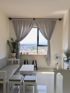 a living room with a couch and a large window at JACY Apartment - Phan Rang, Ninh Thuan in Phan Rang–Tháp Chàm