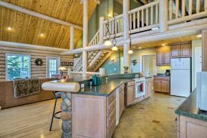 une grande cuisine avec des plafonds en bois et un escalier dans l'établissement Secluded Log Cabin with Game Room and Forest Views, à Red Feather Lakes