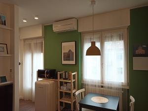 a kitchen with green walls and a table and a refrigerator at FIUGGI12 in Milan