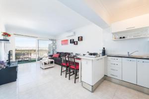 a kitchen with white cabinets and a living room at Apartamento Carole in Port d'Alcudia