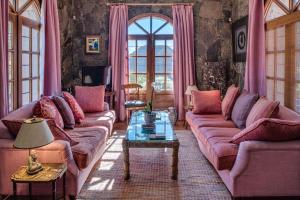 een woonkamer met roze banken en een tafel bij Luxury villa in Nature with Swimming pool Luxus-Finca in der Natur mit pool, Finca de lujo en la naturaleza con piscina in El Retamar