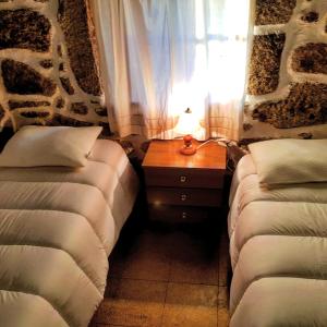 una camera con due letti e un tavolo con una lampada di Dona Gracia Belmonte a Belmonte