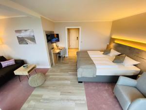 ein Hotelzimmer mit einem Bett und einem Sofa in der Unterkunft Wattenkieker in Cuxhaven
