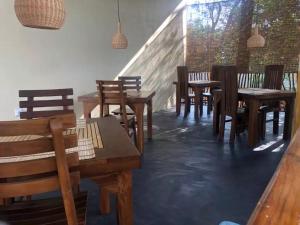 un gruppo di tavoli e sedie in legno in un ristorante di skyresort a Tangalle Altre 37 foto