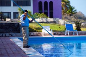 Un homme bloque une piscine avec un tuyau dans l'établissement Hotel Tucan Siho Playa, à Sihoplaya