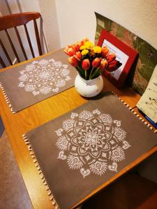 een tafel met twee matten en een vaas met bloemen bij Heidi's Home in Garmisch-Partenkirchen