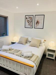 - une chambre avec un grand lit blanc et deux lampes dans l'établissement Free Parking Stylish 3 Bed With Garden, à Taunton