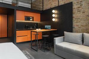 a room with a couch and a kitchen with a table at Globe Runner Rooms & Dorms in Kyiv