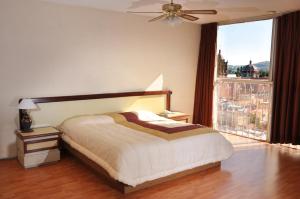 1 dormitorio con cama y ventana grande en Hotel El Monte en Salamanca
