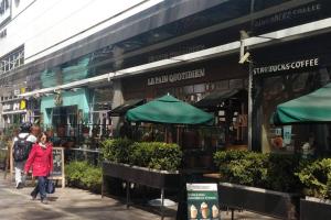a woman walking down a sidewalk in front of a store at RECOLETA APART in Buenos Aires