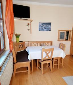una sala da pranzo con tavolo, sedie e TV di Apartments Haus Morgensonne a Reidling