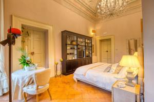 a bedroom with a bed and a table and a chair at Corte Rossetti Le Dimore Luxury B&B in Vasto