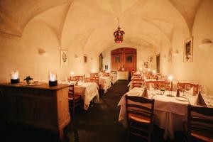 a dining room with tables and chairs and a chandelier at Ca' del Borgo, Rooms & Suites in Poschiavo