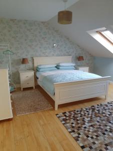 a bedroom with a white bed and a rug at Los Molinos in Tralee