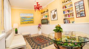 een woonkamer met een glazen tafel en boekenplanken bij Hotel Antille e Azzorre in Lido di Jesolo