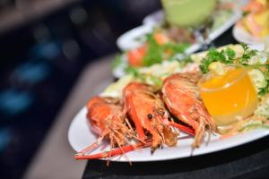 a plate of food with lobster on a table at Agbo Hotel in Polonnaruwa